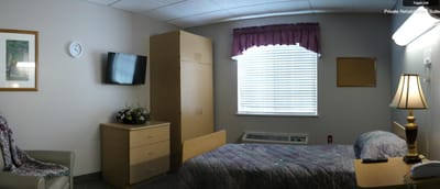 Interior view of a private resident room with a bed