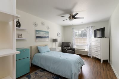 A private resident room with a bed and seating area