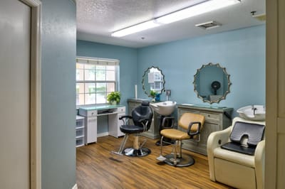 Brightly lit salon area with hair styling chairs