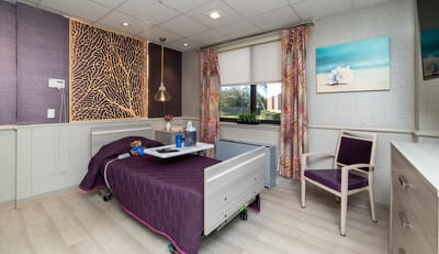 A well-decorated resident room with a purple bedspread