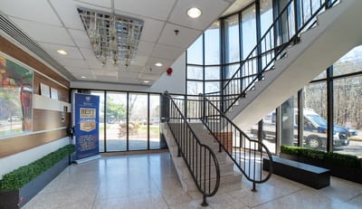 Bright entrance lobby with staircase and artwork