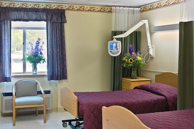 A cozy resident room with two beds and flowers