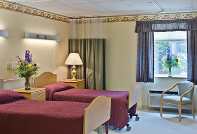 Cozy resident room with two beds and floral decor