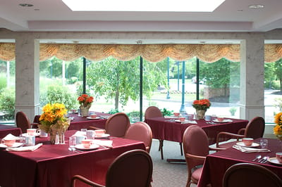 Dining room set with tables and floral arrangements
