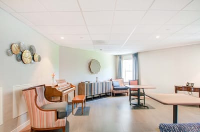 Bright common area with seating and a piano