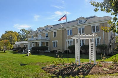 Exterior view of King's Daughters Home with landscaping and flag
