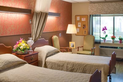 Cozy resident room with two beds and floral decorations