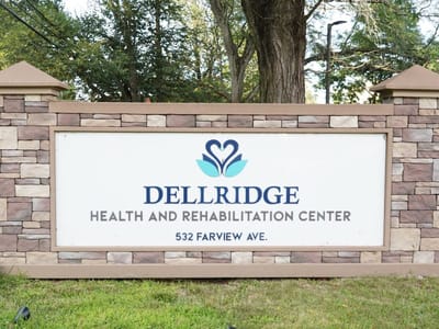 Facility logo on a stone sign with landscaping