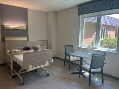 A resident room with a hospital bed and table