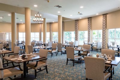 Brightly lit dining room with tables set for meals