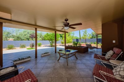 Covered outdoor patio space with seating and greenery