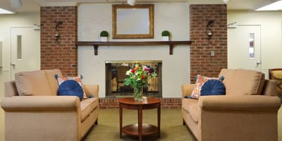 Cozy common area with seating and floral arrangement.