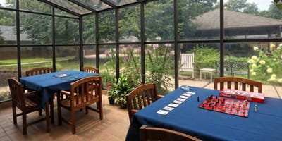 Common area with game tables and a view of the garden.