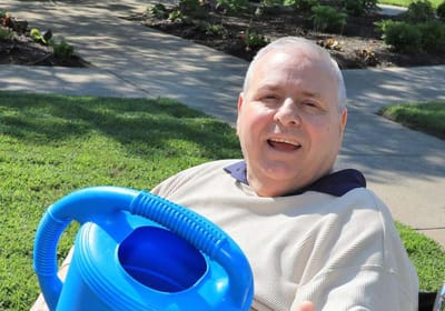 Smiling resident enjoying an outdoor space.