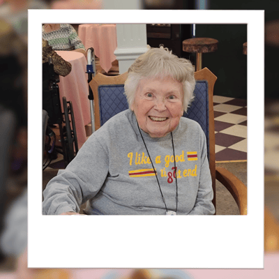 Resident smiling in a common area setting.