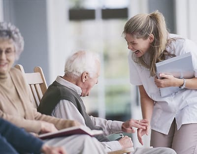 Townhouse Center for Rehabilitation & Nursing, Nursing Home in Uniondale, NY — Caregiver interacting with a resident in a nursing home