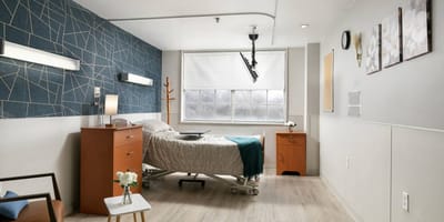 Private resident room with a bed and nightstand.