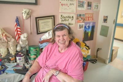 Townhouse Center for Rehabilitation & Nursing, Nursing Home in Uniondale, NY — Smiling resident in a colorful room with decorations