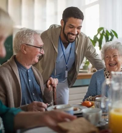 Residents and staff enjoying a meal together.