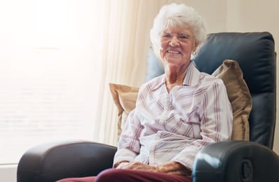 Smiling elderly woman in a cozy chair