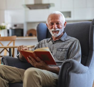 Senior man enjoying a book in a cozy chair