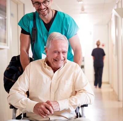 Care staff assisting a resident in a hallway