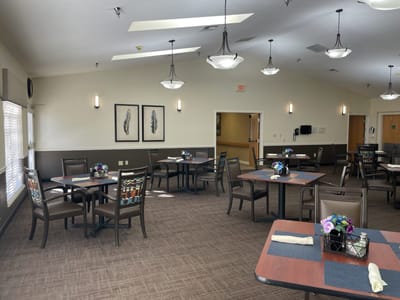 Dining area with tables and floral centerpieces.