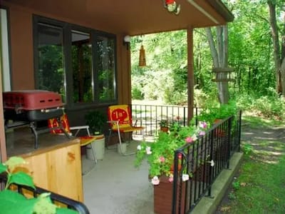 Covered porch with chairs and greenery