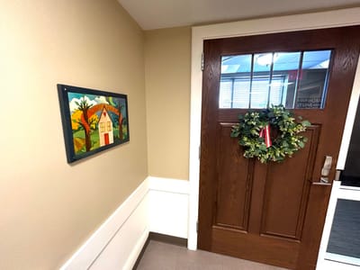 Decorative wall outside a door with greenery.