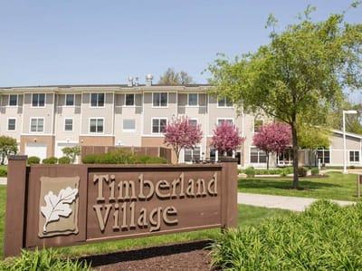 Exterior view of Timberland Village with landscaping.