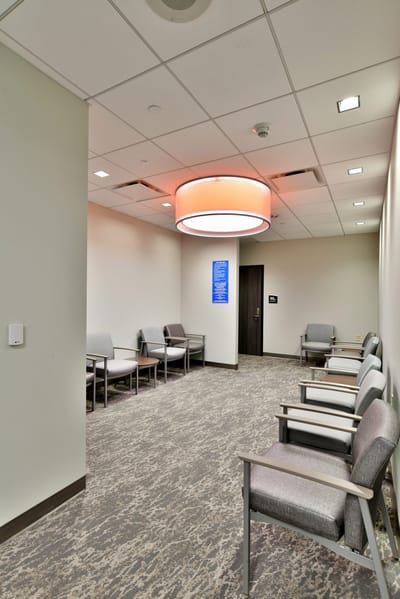 Interior waiting area with chairs and modern lighting.