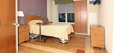 Cozy resident room with bed and furniture.
