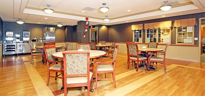 Dining area with tables and chairs in a warm setting.