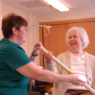 Staff assisting a resident in a friendly interaction.