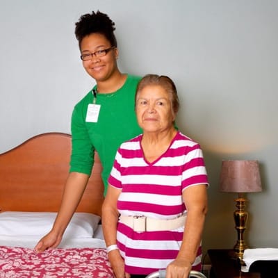 A staff member assisting a resident in a room