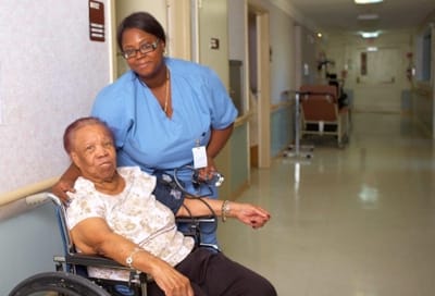 Staff member assisting a resident in the hallway.