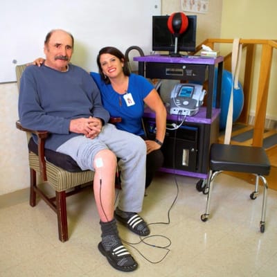 Therapist assisting a resident in a rehabilitation session.
