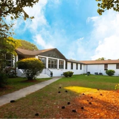 Exterior view of a senior care facility surrounded by greenery.