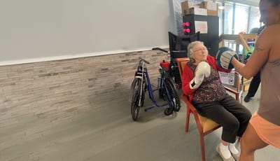 Elderly woman boxing with staff support