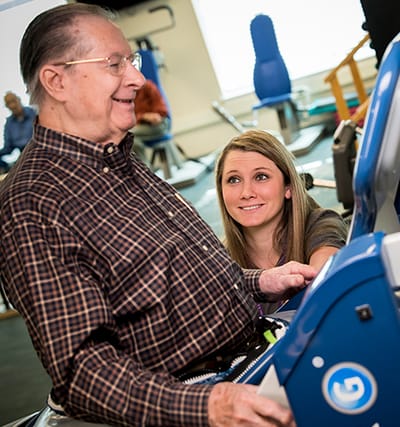 Older man engaging in therapy with a staff member.