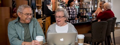 Two residents enjoying coffee and conversation indoors.
