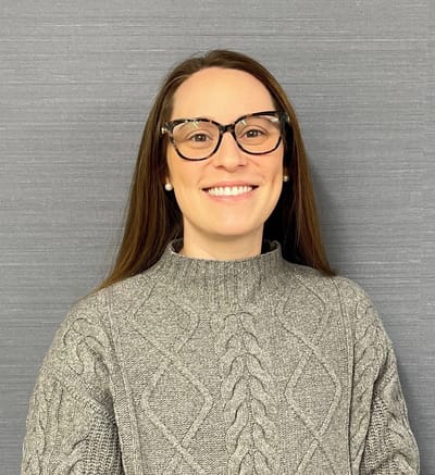Smiling staff member in a cozy sweater