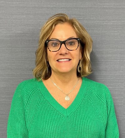 Smiling staff member in green sweater