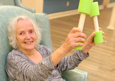 Resident engaging in a fun activity with foam pieces.