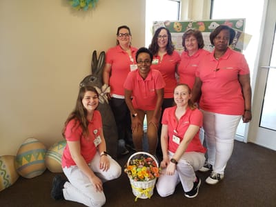 Staff members posing with Easter decorations.