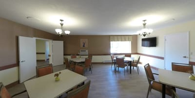 Sunny common area with tables and chairs.