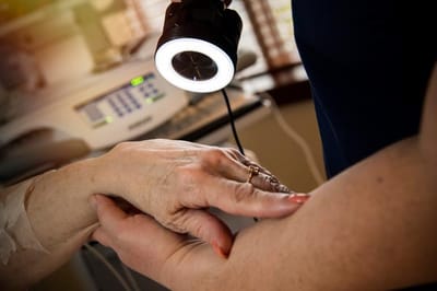 Hands of two people interacting in a care setting.