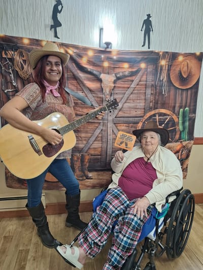 Resident enjoying music with staff during an event.
