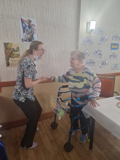 Care staff assisting an elderly resident in a celebration
