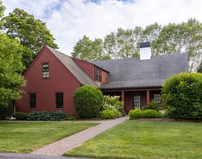 Exterior view of a red house with landscaping.